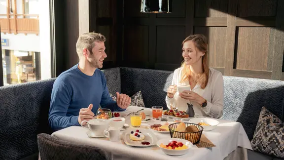 A happy couple sharing a delicious, varied breakfast with one another within the Hotel